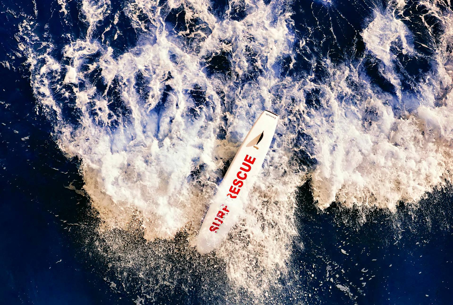 Rettungsboot mit der Aufschrift „Surf Rescue“ kämpft sich durch aufgewühlte Wellen auf offener See.